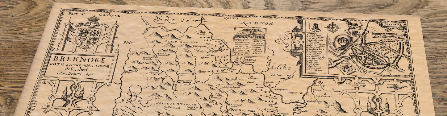 Upper section of Brekon - an old map by John Speed, lying at an angle on an antique ash table
