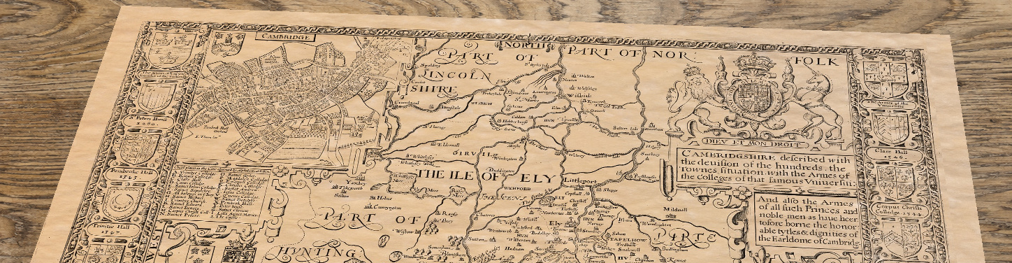 Upper section of John Speed’s Cambridgeshire map lying at an angle on an antique ash table
