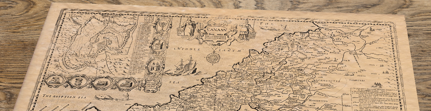 Upper section of The Holy Land - an old map by John Speed, lying at an angle on an antique ash table