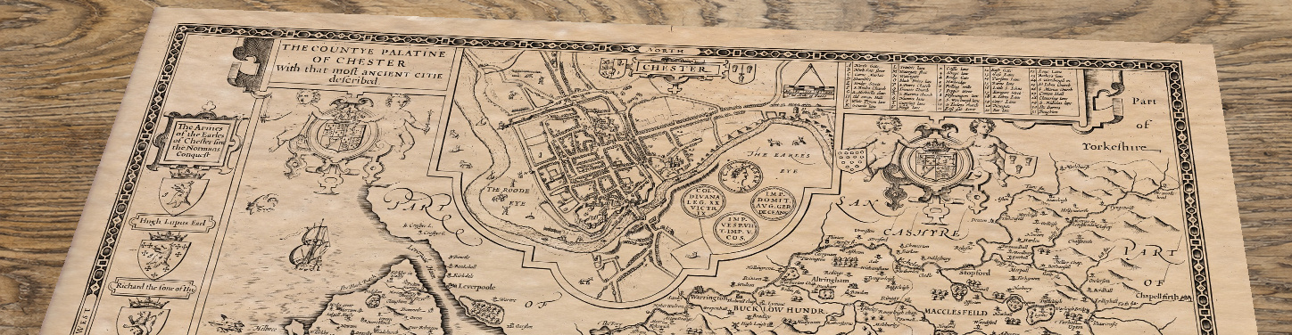 Upper section of Old Map of Cheshire, lying at an angle on an antique ash table