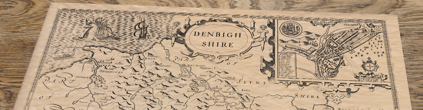 Upper section of Old Map of Denbighshire, lying at an angle on an antique ash table