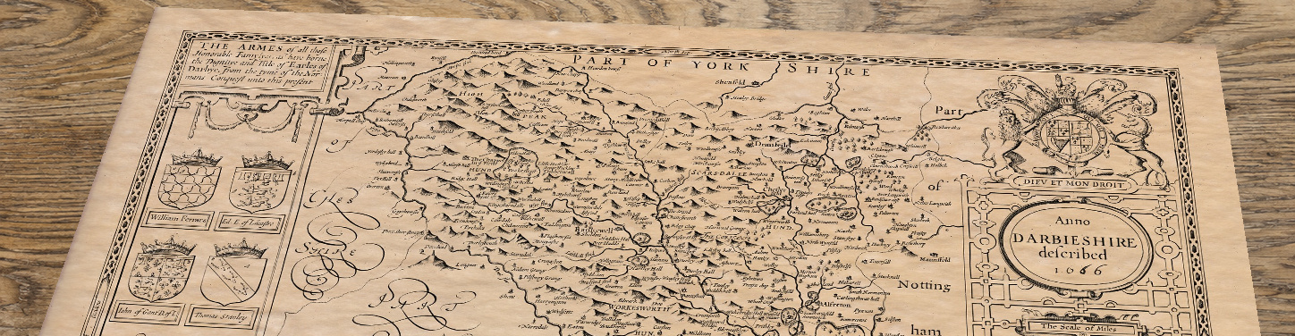 Upper section of Derby - an old map by John Speed, lying at an angle on an antique ash table