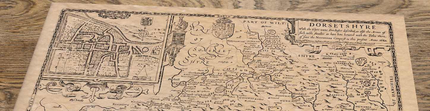 Upper section of Old Map of Dorset, lying at an angle on an antique ash table