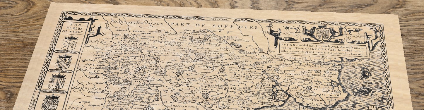 Upper section of Old Map of Essex, lying at an angle on an antique ash table