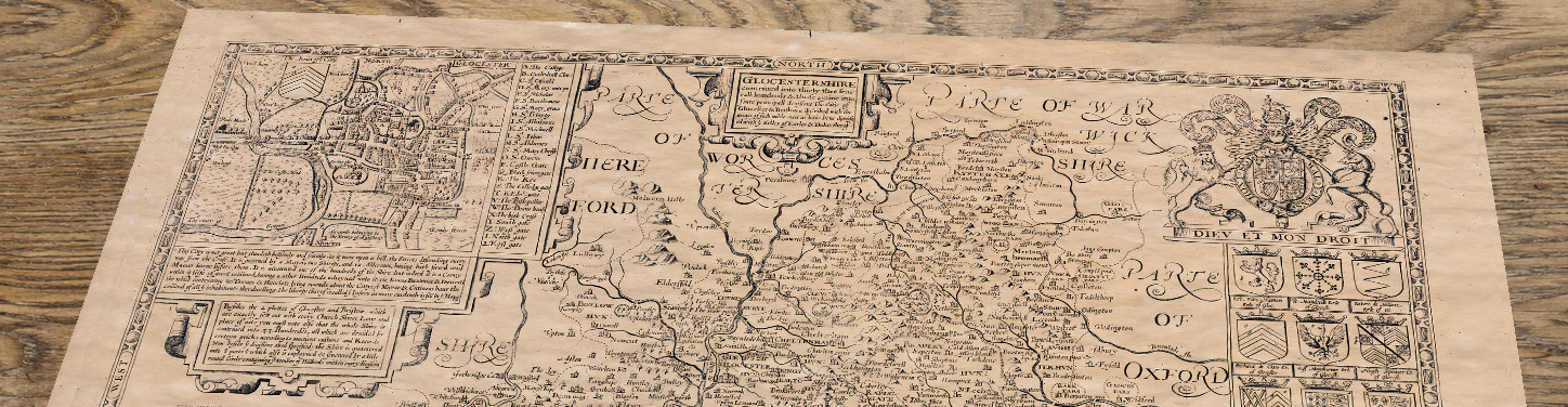 Upper section of Old Map of Gloucestershire, lying at an angle on an antique ash table