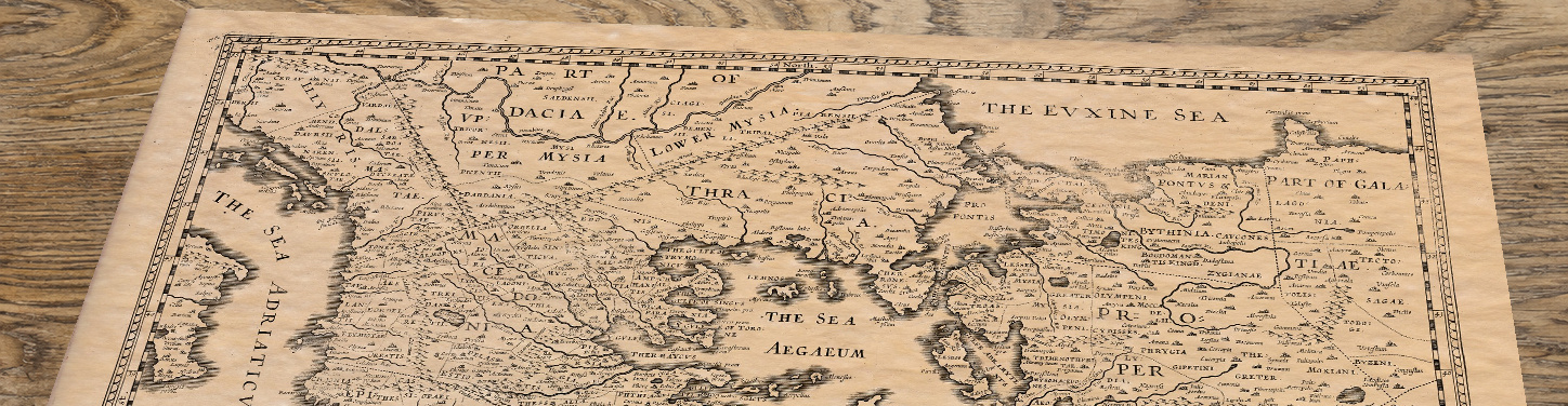 Upper section of Greece - an old map by John Speed, lying at an angle on an antique ash table