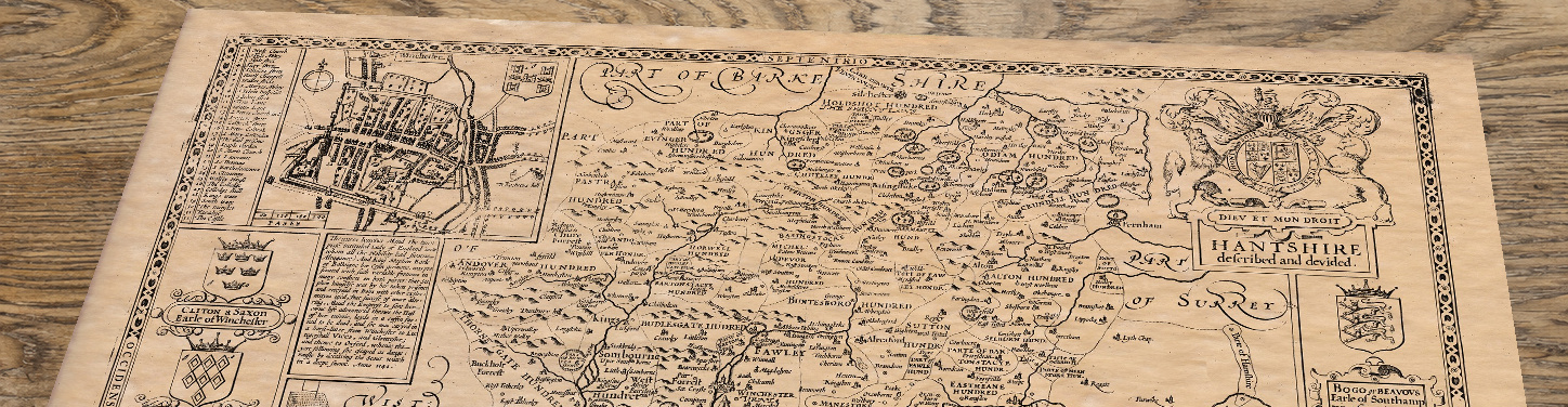 Upper section of Old Map of Hampshire, lying at an angle on an antique ash table