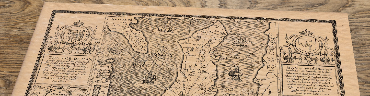 Upper section of Isle of Man - an old map by John Speed, lying at an angle on an antique ash table