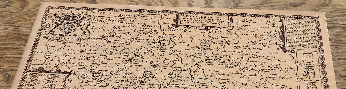 Upper section of Old Map of Leicestershire, lying at an angle on an antique ash table