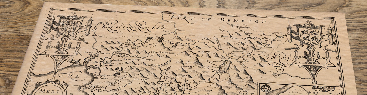 Upper section of Merionethshire- an old map by John Speed, lying at an angle on an antique ash table