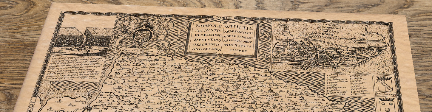 Upper section of Old Map of Norfolk, lying at an angle on an antique ash table