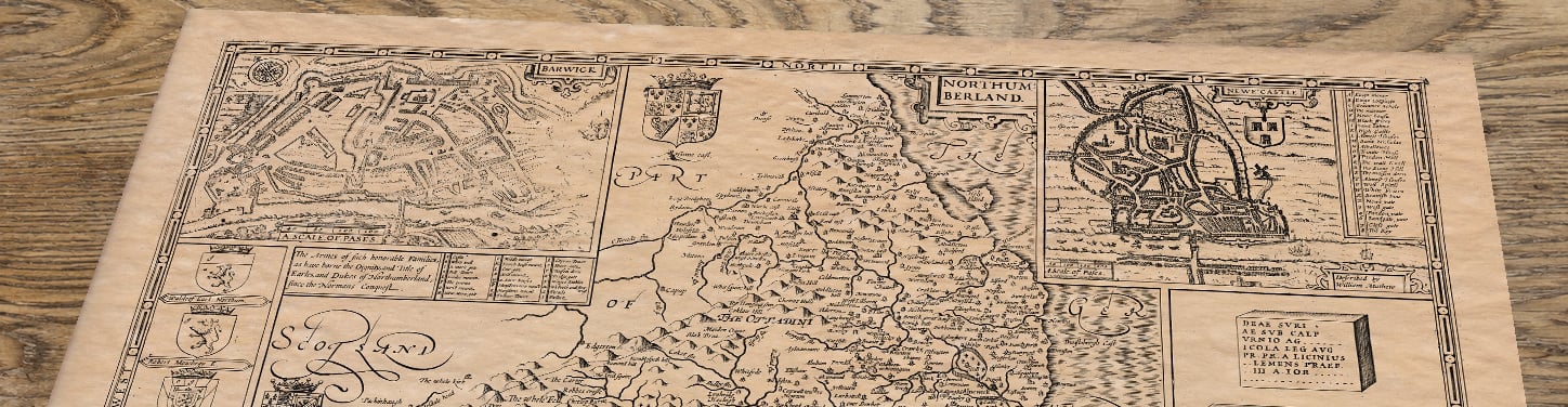 Upper section of Old Map of Northumberland, lying at an angle on an antique ash table
