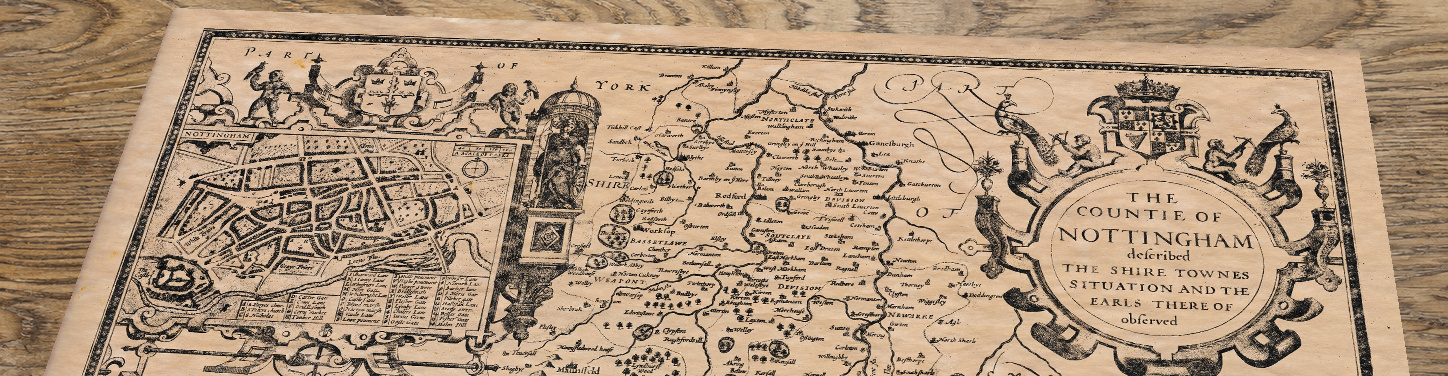 Upper section of Old Map of Nottinghamshire, lying at an angle on an antique ash table