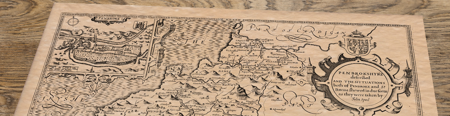 Upper section of Pembrokeshire - an old map by John Speed, lying at an angle on an antique ash table