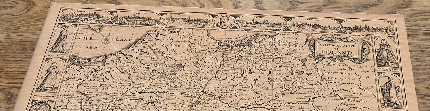 Upper section of Old Map of Poland by John Speed, lying at an angle on an antique ash table