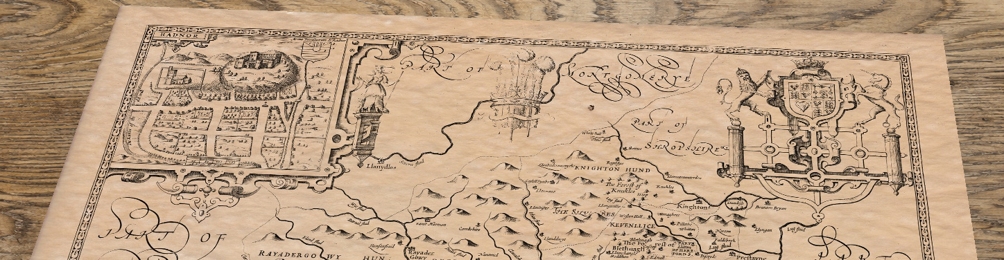 Upper section of Radnor - an old map by John Speed, lying at an angle on an antique ash table