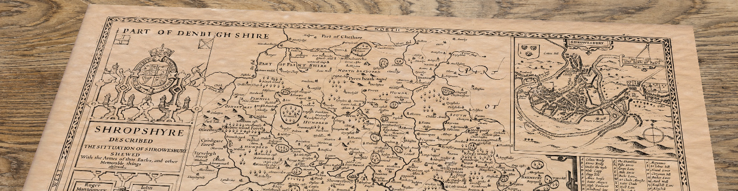 Upper section of Shropshire - an old map by John Speed, lying at an angle on an antique ash table