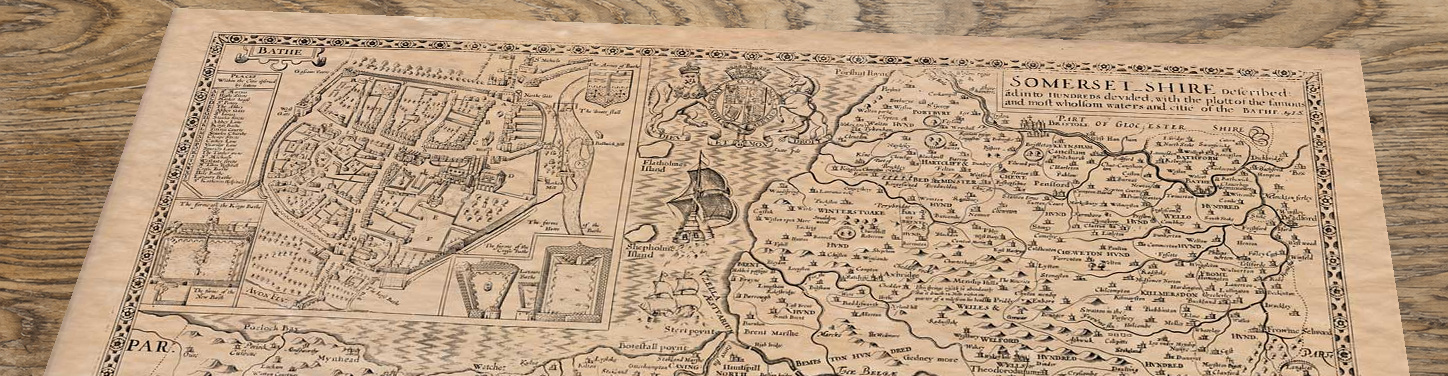 Upper section of Somerset - an old map by John Speed, lying at an angle on an antique ash table